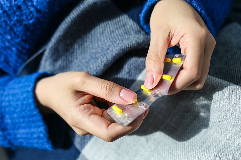 woman taking pills out of package
